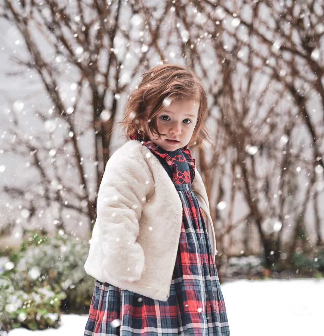 Amelie playing in the snow in her handmade Ninon smocked dress