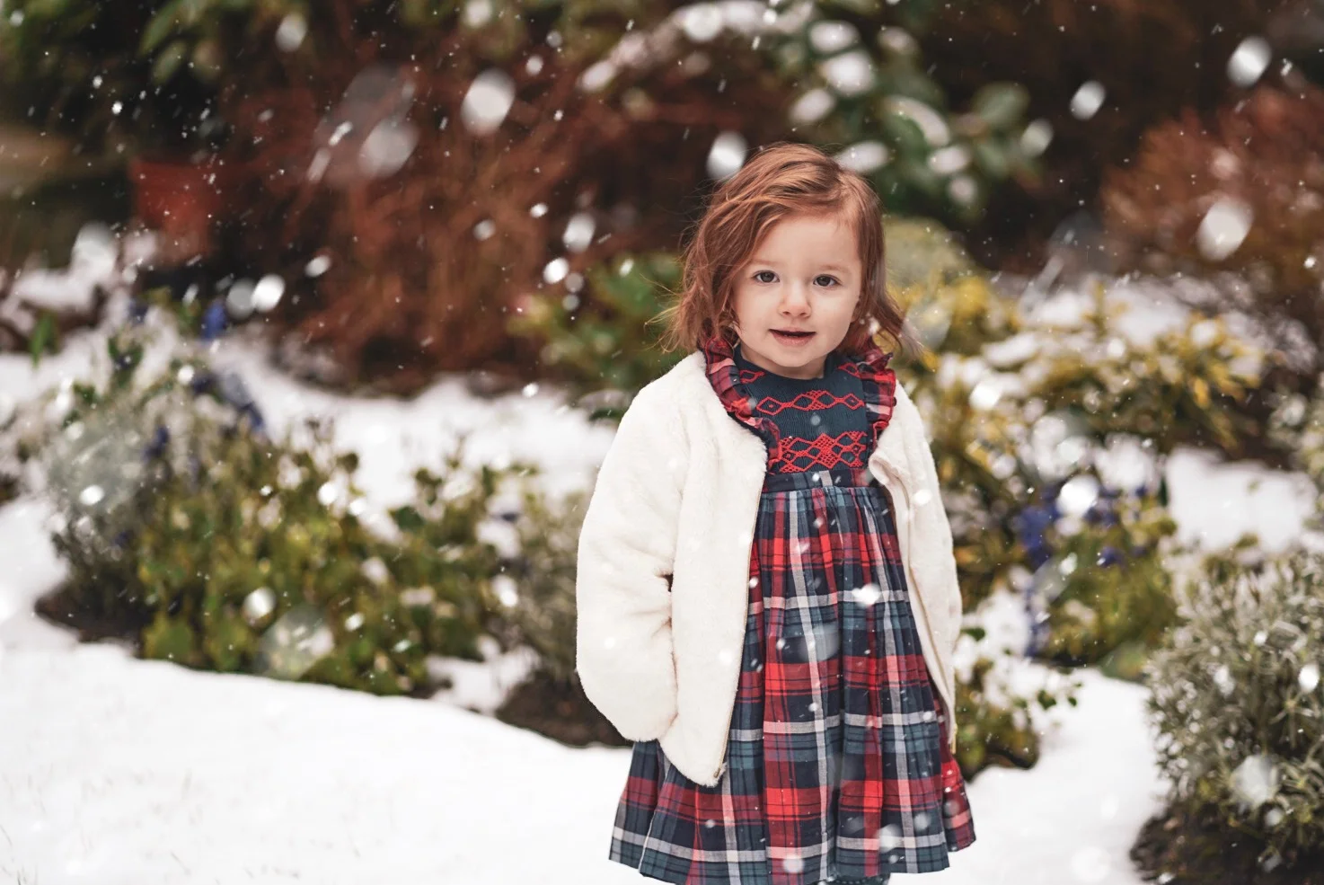 Amelie playing in the snow in her handmade Ninon smocked dress
