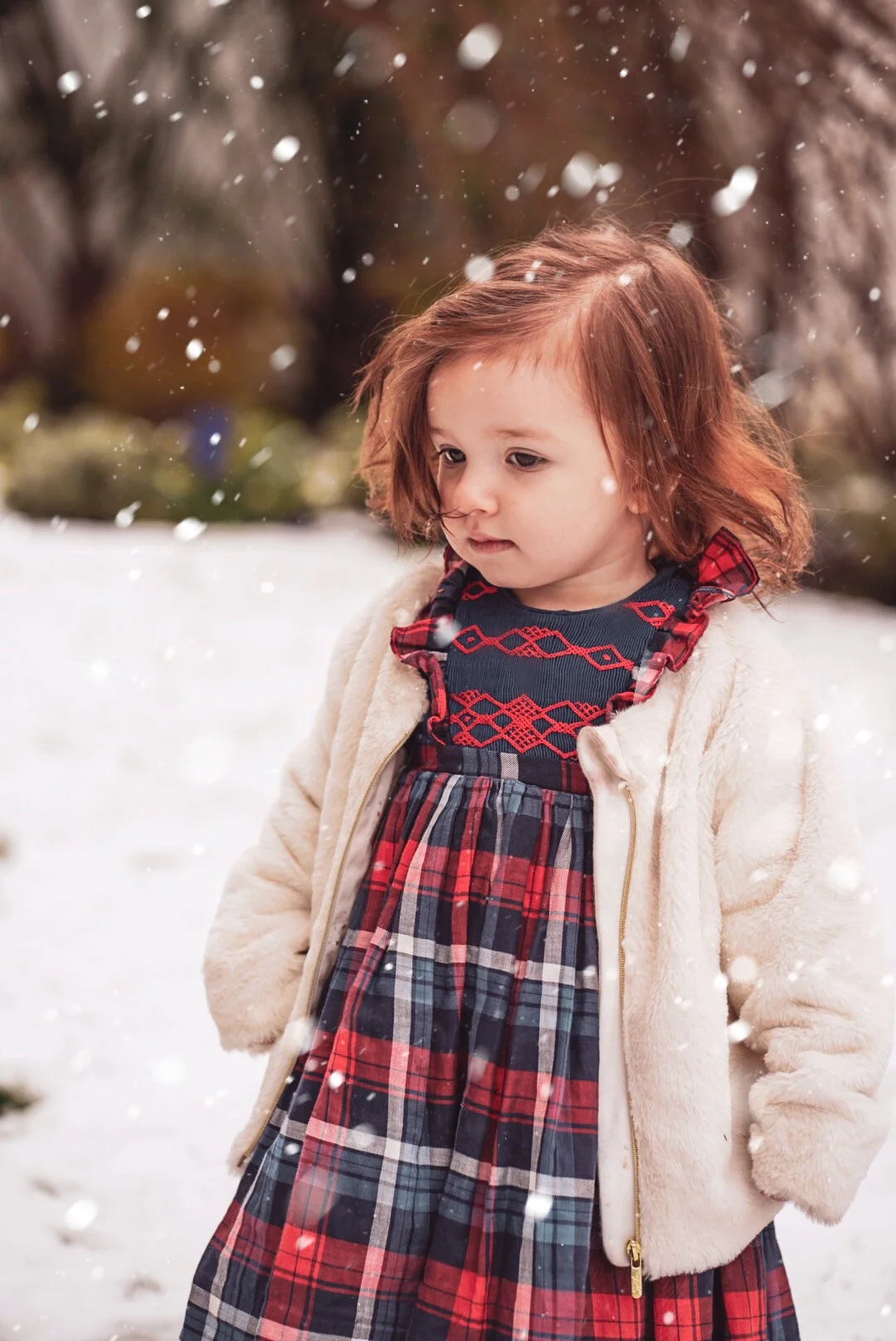 Amelie playing in the snow in her handmade Ninon smocked dress