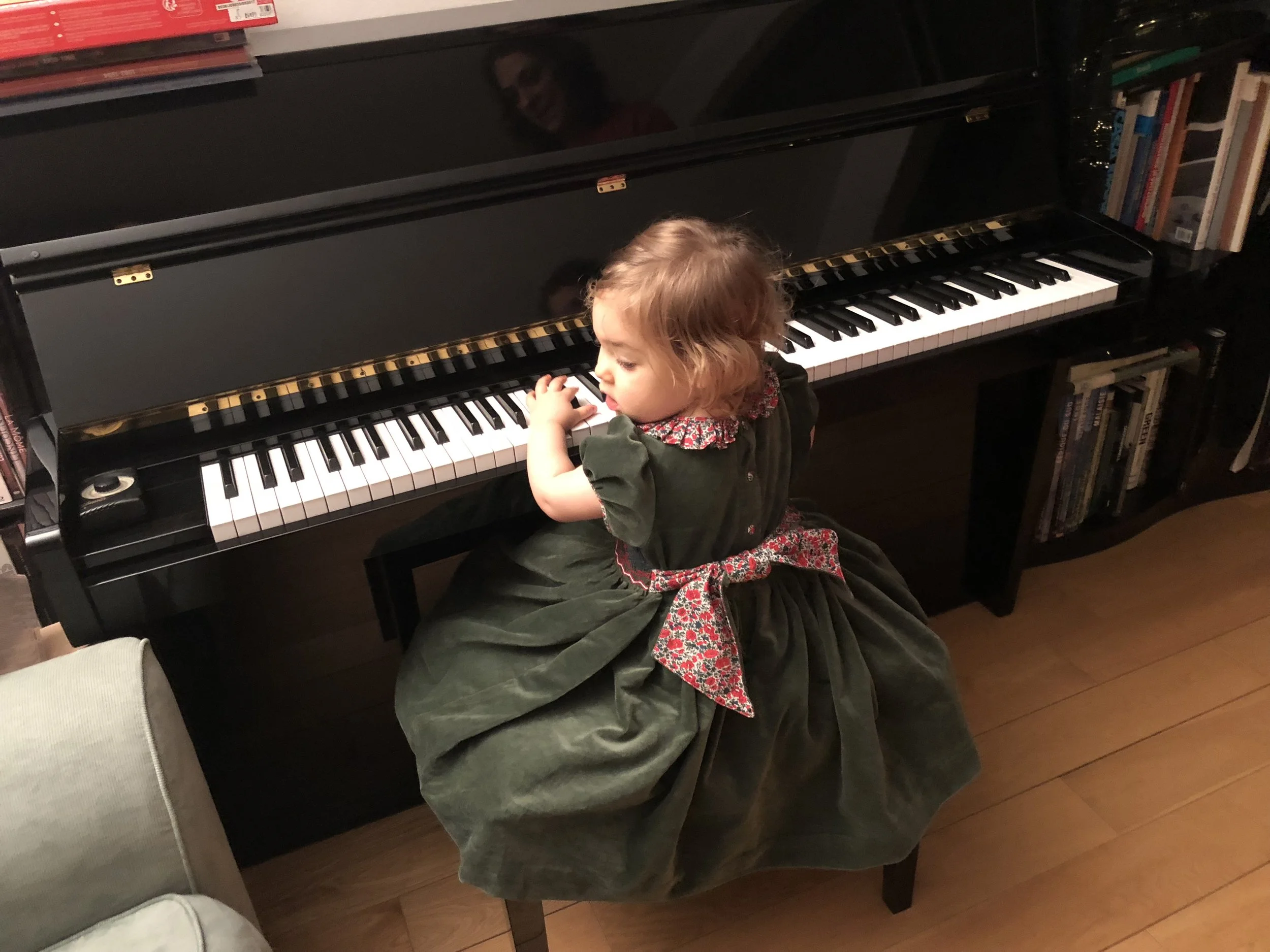Beautiful Chiara playing the piano at Christmas in our fir green Liberty collar Amandine dress